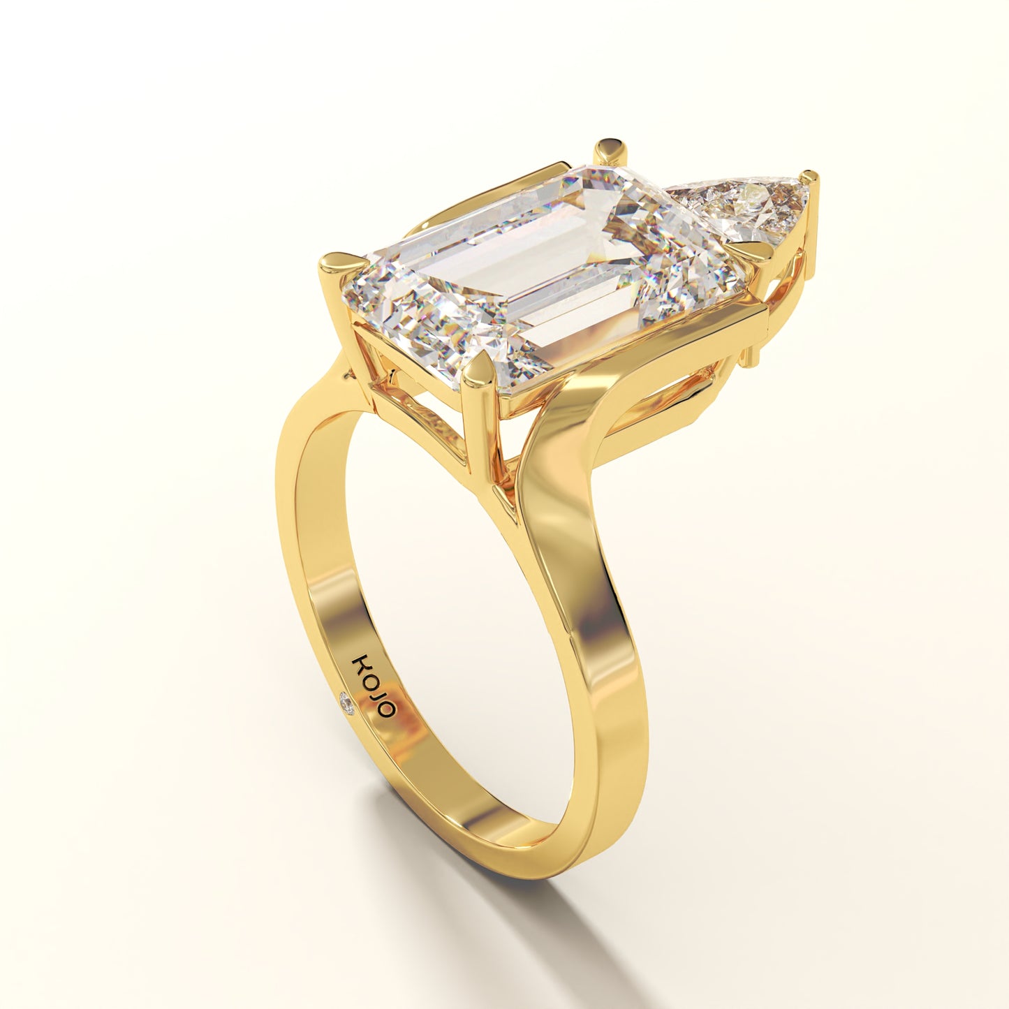 Emerald-cut lab-grown diamond engagement ring in 18K yellow gold with trillion side stone.