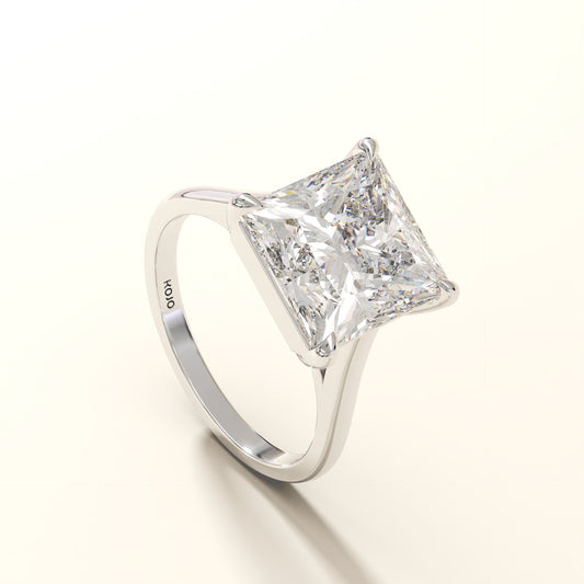 Diamond ring with a princess cut diamond on a white background