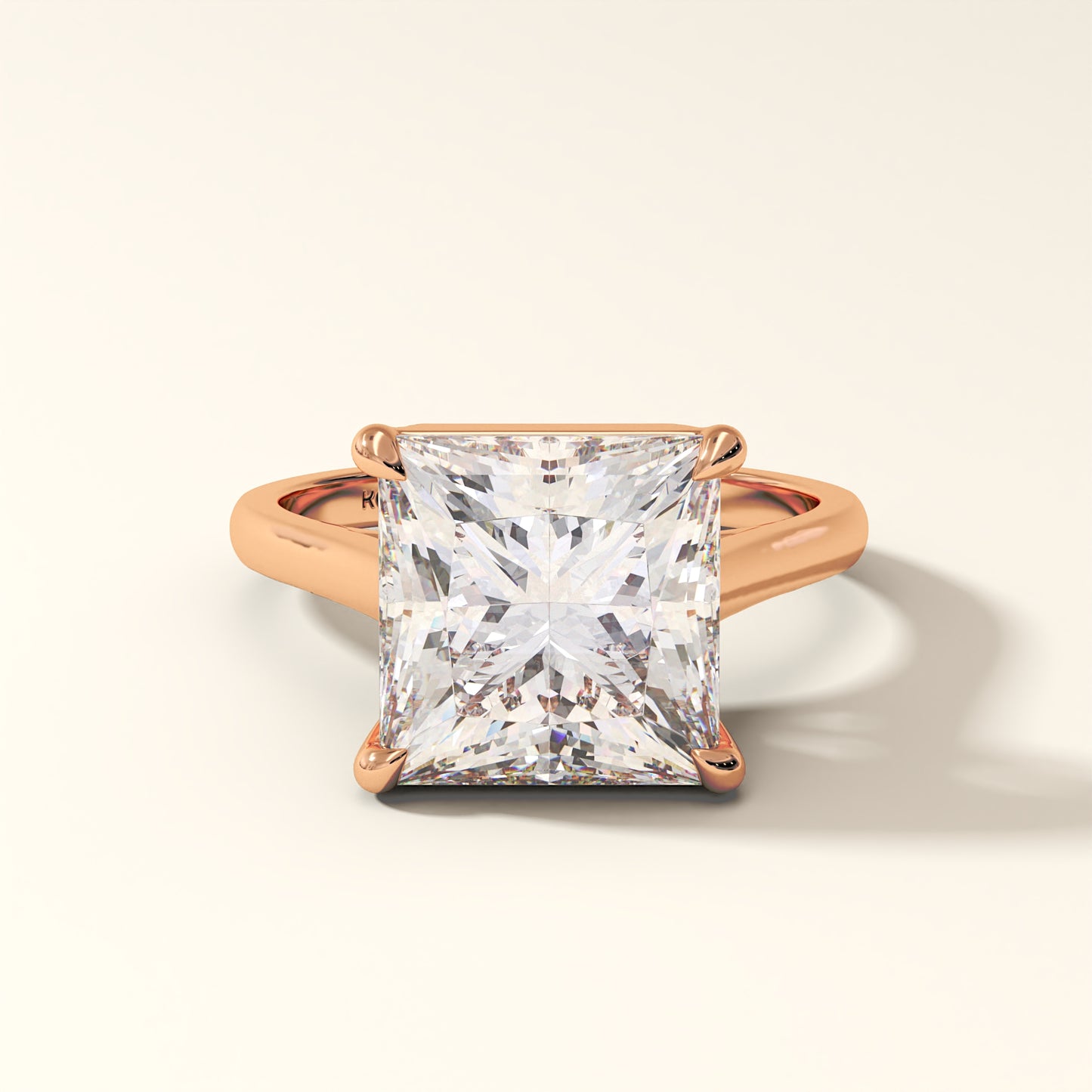 Rose gold ring with a large princess-cut diamond on a light background.