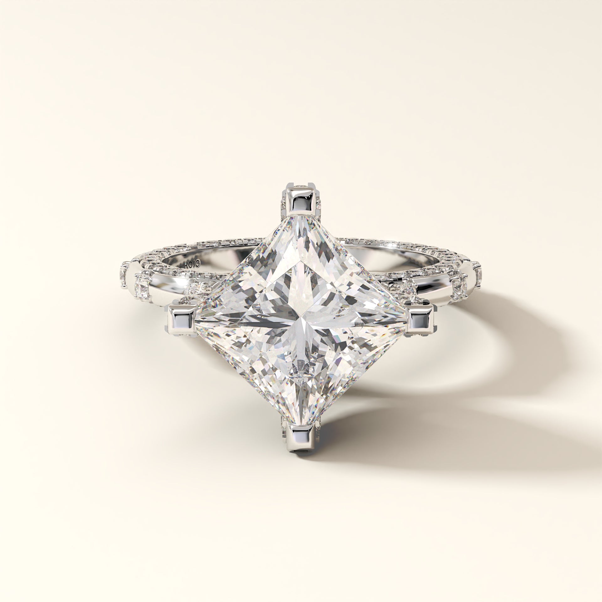 Princess-cut diamond ring with round brilliant diamonds on a light background
