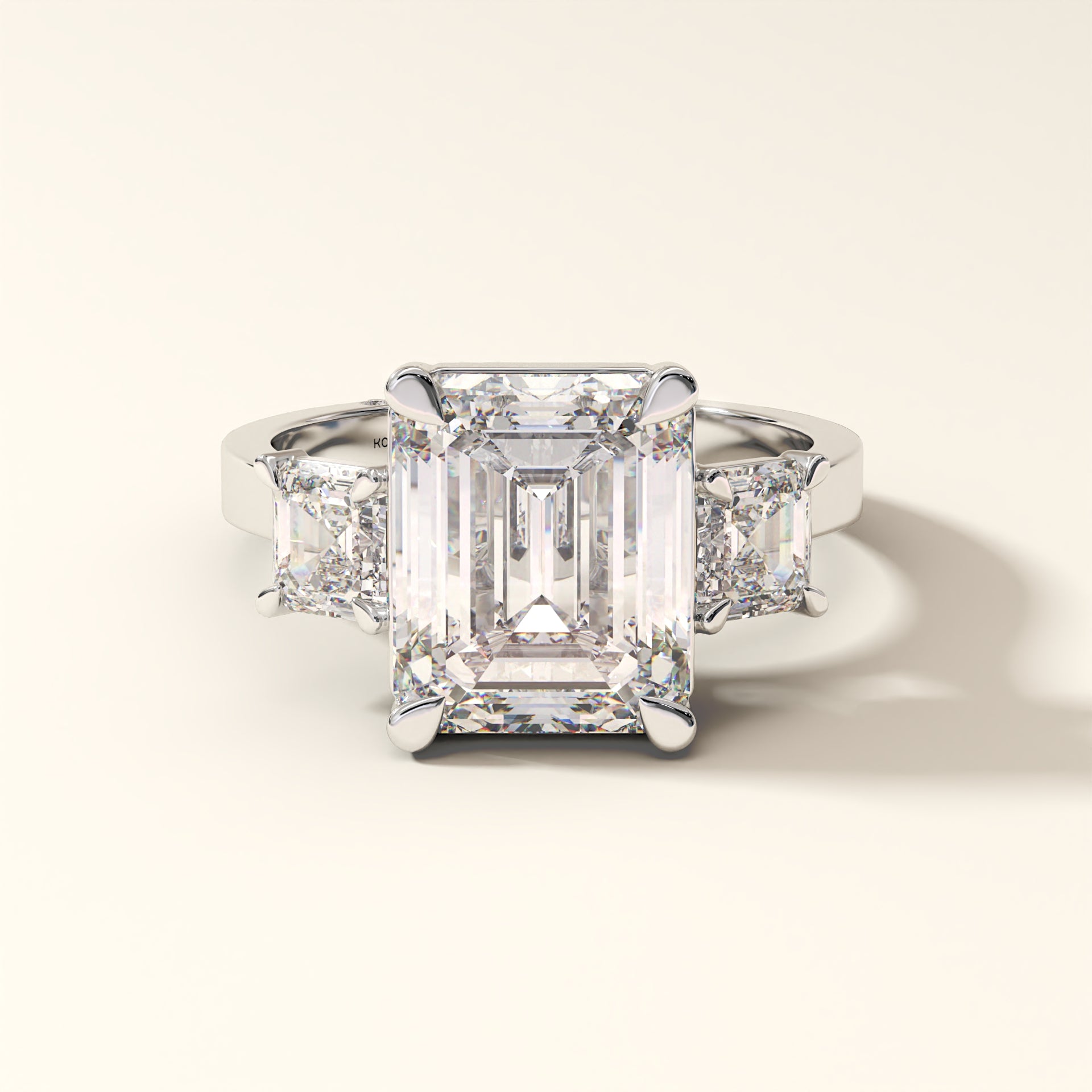 Emerald-cut lab-grown diamond three-stone engagement ring with Asscher side stones in white gold.