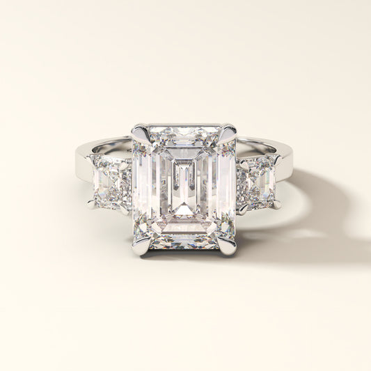 Emerald-cut lab-grown diamond three-stone engagement ring with Asscher side stones in white gold.