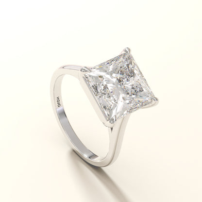 Diamond ring with a princess cut diamond on a white background