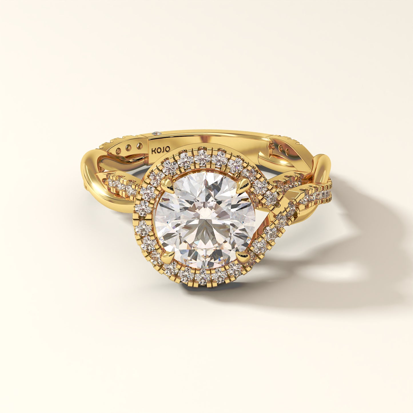 2 carat round-cut lab grown diamond ring in yellow gold, encircled by a radiant halo and a twisted shank.