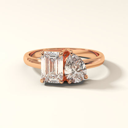 Rose gold two stone ring with emerald and pear cut diamonds