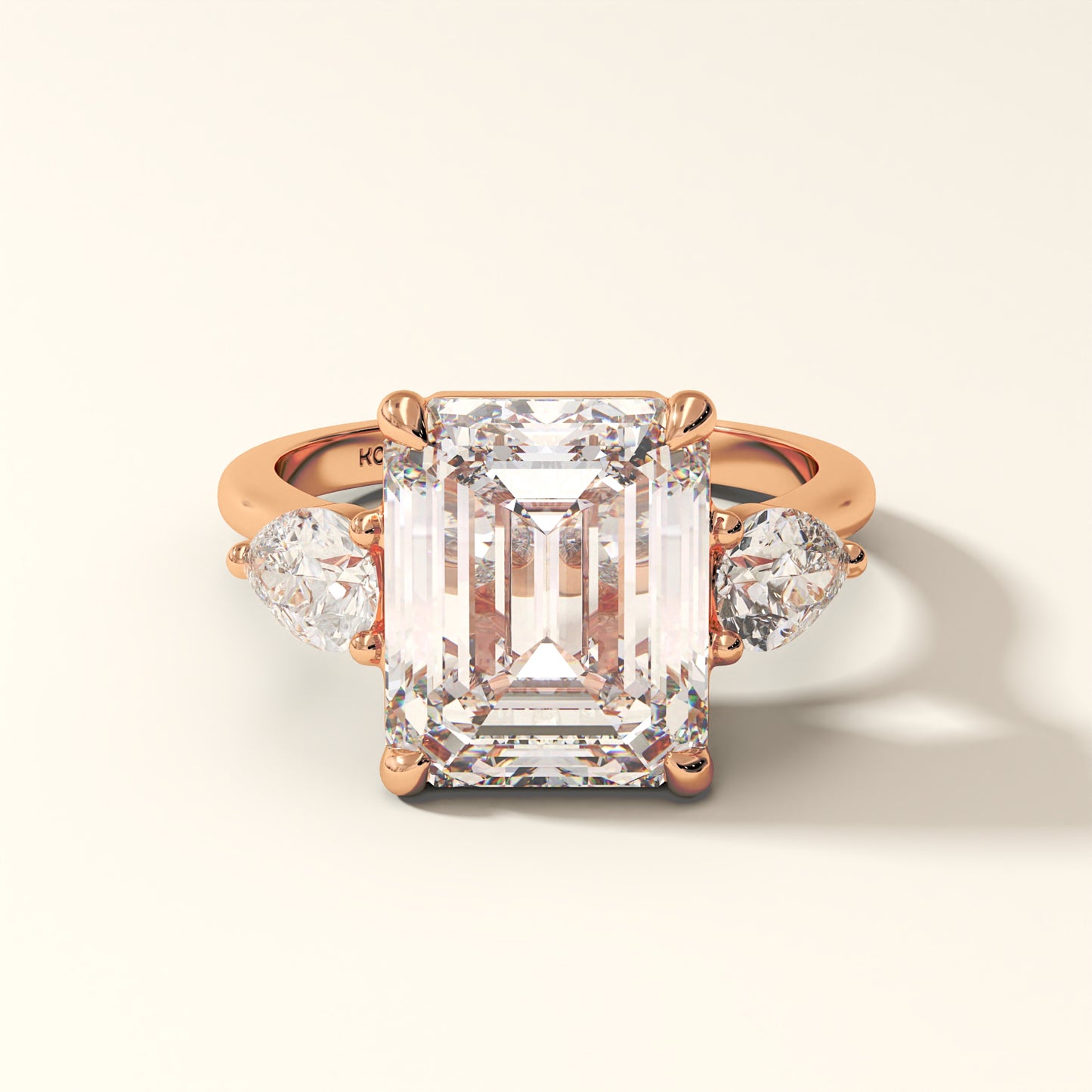 Luxury emerald cut lab grown diamond ring in 18K gold with pear side stones in rose gold